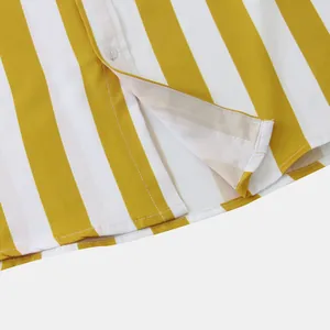 Primo piano dettagliato dell'orlo e del bottone bianco su una camicia a righe gialle