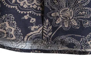 Detailed view of the vintage floral pattern and hem of this navy blue Hawaiian shirt