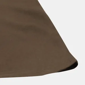 Macro detail shot showing the brown fabric texture and hem stitching of a men's casual shirt