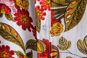 Close-up detail of vibrant floral print and button on a men's summer shirt