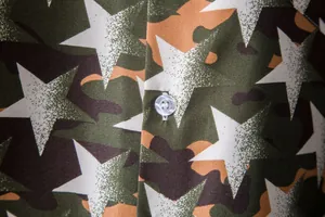 Macro detail of camouflage Hawaiian shirt with star print and button closure