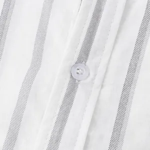 Macro view of white and grey striped linen fabric with a white button on a mens shirt