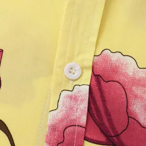 Close-up of yellow men's shirt fabric featuring vibrant floral print and white button detail