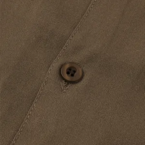 Detailed close-up of brown casual men's shirt showing high-quality fabric and button.