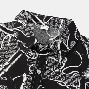 Dettaglio ravvicinato del colletto di una camicia da uomo con stampa paisley bianca e nera
