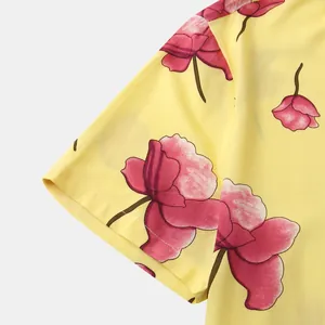 Close-up of yellow men's shirt fabric featuring pink floral prints and sleeve stitching