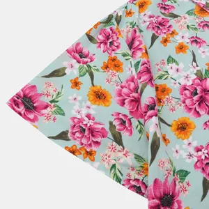 Detaillierte Nahaufnahme des bunten Blumenmusters auf einem minzgrünen Hawaiihemd