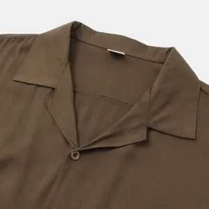 Detailed macro view of the collar and button on a brown men's casual short sleeve shirt