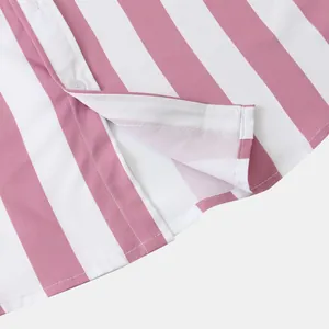 Dettaglio dello spacco laterale e delle cuciture della camicia a righe bianche e rosa