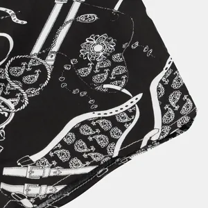 Dettaglio ravvicinato della stampa paisley e cintura su camicia estiva da uomo nera
