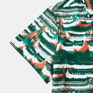 Gros plan sur l'imprimé abstrait vert et orange vif sur la manche d'une chemise homme