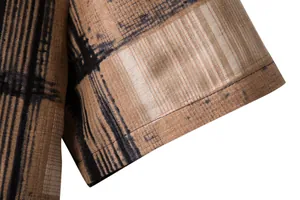 Close-up detail of a men's linen-blend shirt sleeve with abstract brown and black print.