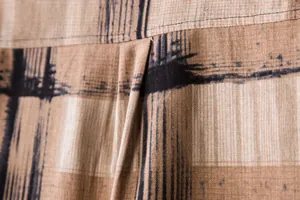 Macro close-up of men's brown linen shirt showing fabric texture and black print.