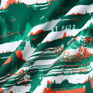 Gros plan d'un motif de paysage abstrait vert et orange sur le tissu de chemise hawaïenne