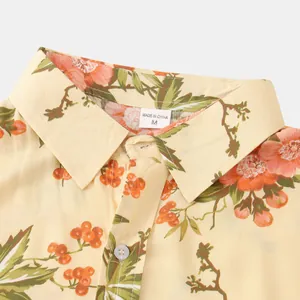 Vista dettagliata del colletto di una camicia floreale da uomo con etichetta taglia M.