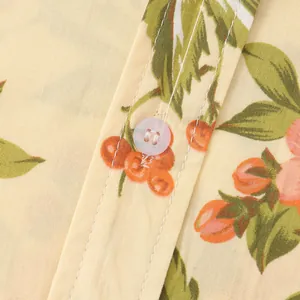 Primo piano di una camicia da uomo a fiori che mostra la trama del tessuto e il bottone