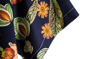 Macro view showing the detailed floral print and stitching of a men's summer shirt