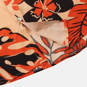 Macro view of the hem stitching and floral print detail on a summer short-sleeve men's shirt