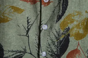 Detailed macro view of retro floral men's shirt showing linen fabric texture and buttons