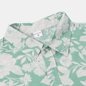 Detailansicht eines grünen Hawaiihemdes mit Blumenmuster und dem Größenetikett M