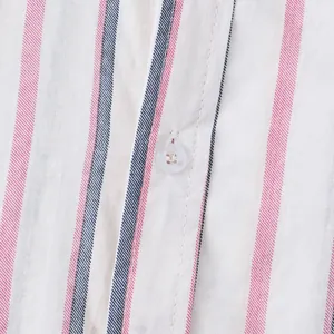 Close-up macro detail of red and navy striped cotton shirt fabric with white button