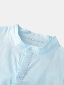 Close-up detail showing the stand collar and buttons on a light blue linen shirt