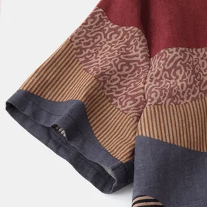 Close-up of ethnic style printed shirt sleeve showing linen fabric texture and colorful patterns.