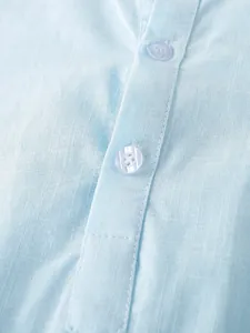 Close-up view showing the light blue linen cotton shirt fabric texture and buttons