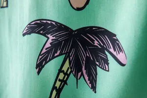 Close-up of palm tree print on green men's Hawaiian short sleeve shirt fabric