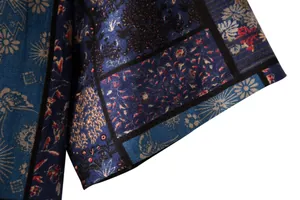 Detail of men's floral linen shirt sleeve showing intricate patchwork print and fabric texture