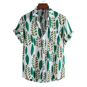 Detailed macro view of tropical green leaf print on white short-sleeved casual shirt.