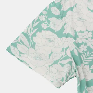 Nahaufnahme der kurzen Ärmelmanschette eines mintgrünen Hawaiihemds mit Blumenmuster