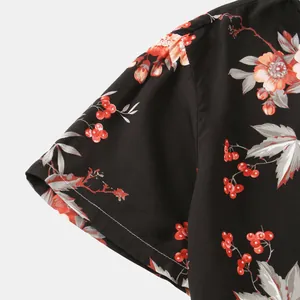Vista dettagliata del motivo floreale con bacche rosse su camicia a maniche corte da uomo