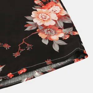 Primo piano di camicia floreale nera da uomo con dettagli di stampa di fiori e cuciture