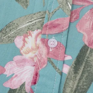 Detailansicht von Knopf und Blumenmuster auf einem hawaiianischen Strandhemd für Herren.