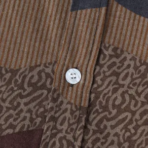 Detailed macro view of ethnic floral fabric and pearlescent button on men's casual shirt