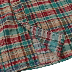 Detailed macro view of the white double stitching and plaid fabric on a casual shirt