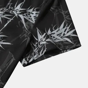 Détail du motif de feuilles de bambou gris sur le tissu noir d'une chemise hawaïenne courte
