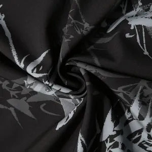 Gros plan détaillé sur un tissu floral hawaïen noir montrant la texture et le drapé