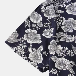 Dettaglio macro del motivo floreale bianco su una camicia da uomo a maniche corte blu navy