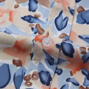 Detailed close-up of a men's floral Hawaiian beach shirt showing button and fabric texture