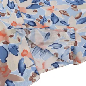 Close-up detail of a men's Hawaiian floral print shirt featuring neat stitching and side hem vent