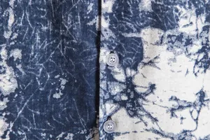 Detail shot of men's vintage Hawaiian floral shirt fabric showing texture and buttons.