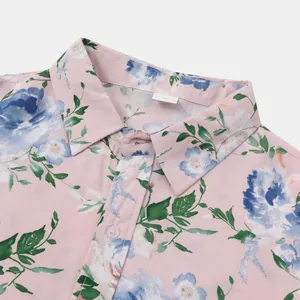 Detailansicht eines rosa kurzärmeligen Hawaiihemds mit blauem Blumendruck und Kragen.