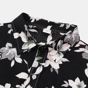 Detailansicht eines schwarzen Hawaiihemd-Kragens mit aufwendigen weißen Blumenmustern