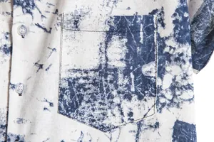 Close-up detail of pocket and buttons on men's blue and white print Hawaiian shirt