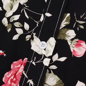 Detailansicht eines schwarzen Herren-Hawaiihemdes mit floralem Muster und weißem Knopf