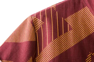 Close-up of burgundy cotton linen shirt fabric with yellow geometric line patterns