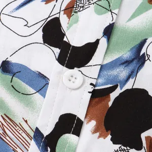 Close-up detail of men's short sleeve shirt featuring colorful abstract floral print and button.