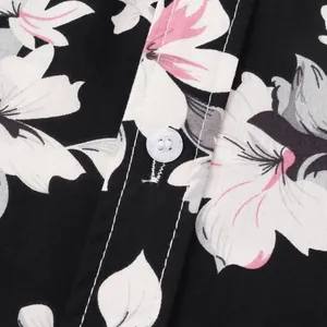 Nahaufnahme eines Hawaii-Blumenhemds mit weißem Knopf und feiner Stoffstruktur